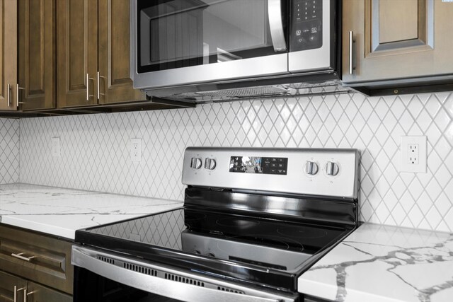 kitchen with light stone countertops, appliances with stainless steel finishes, dark brown cabinetry, and decorative backsplash