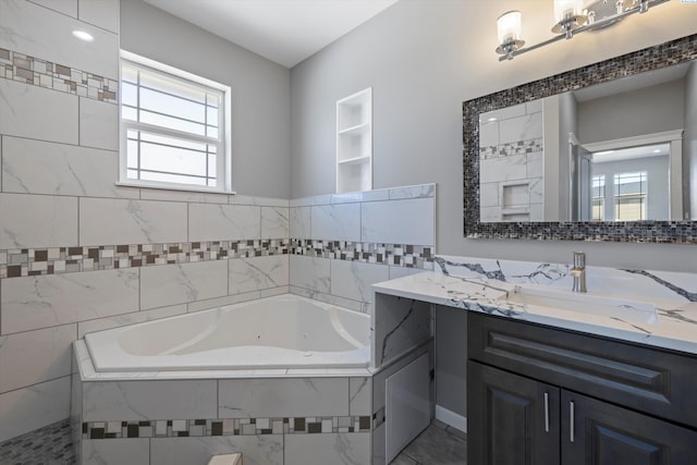 bathroom with vanity and tiled bath