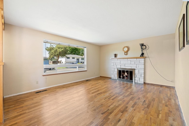 2120 Austin St, Richland, WA 99354 - unfurnished living room featuring wood finished floors, a stone fireplace, and baseboards
