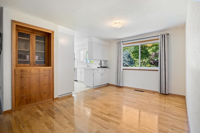 2120 Austin St, Richland, WA 99354 - kitchen featuring light wood-style floors, a sink, and white cabinets