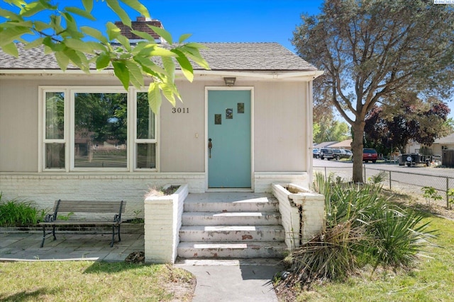 3011 W Hood Ave, Kennewick, WA 99336 - entrance to property featuring fence, brick siding, and roof with shingles