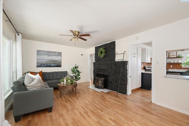 3011 W Hood Ave, Kennewick, WA 99336 - living area with a wood stove, light wood finished floors, ceiling fan, and plenty of natural light