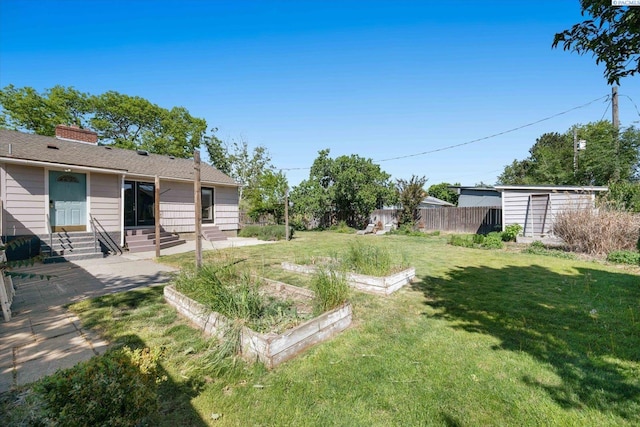 3011 W Hood Ave, Kennewick, WA 99336 - view of yard with entry steps, a vegetable garden, and an outdoor structure