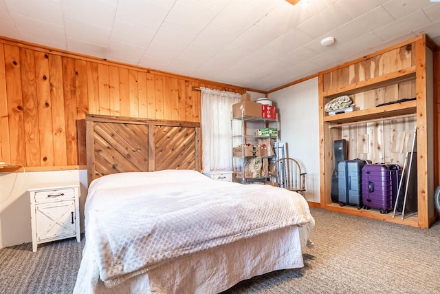 bedroom with wooden walls and dark colored carpet