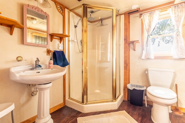 bathroom with hardwood / wood-style flooring, toilet, and a shower with shower door