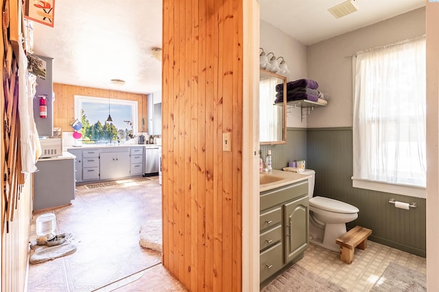 bathroom with a wealth of natural light and wooden walls