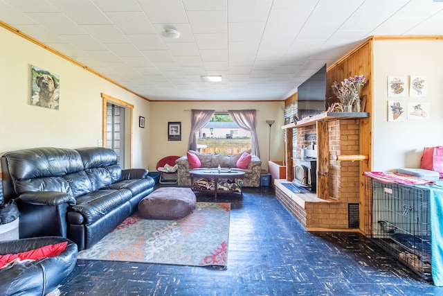 living room featuring a brick fireplace, dark wood-type flooring, and ornamental molding