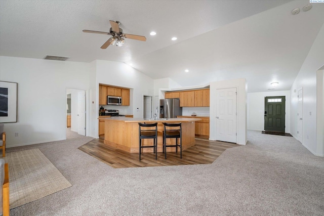 1713 W 39th Ave, Kennewick, WA 99337 - kitchen with appliances with stainless steel finishes, light carpet, lofted ceiling, a kitchen island, and light countertops