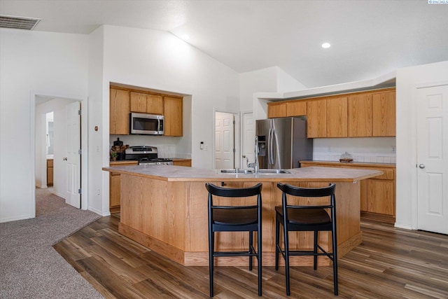 1713 W 39th Ave, Kennewick, WA 99337 - kitchen with appliances with stainless steel finishes, high vaulted ceiling, an island with sink, light countertops, and dark wood-style floors