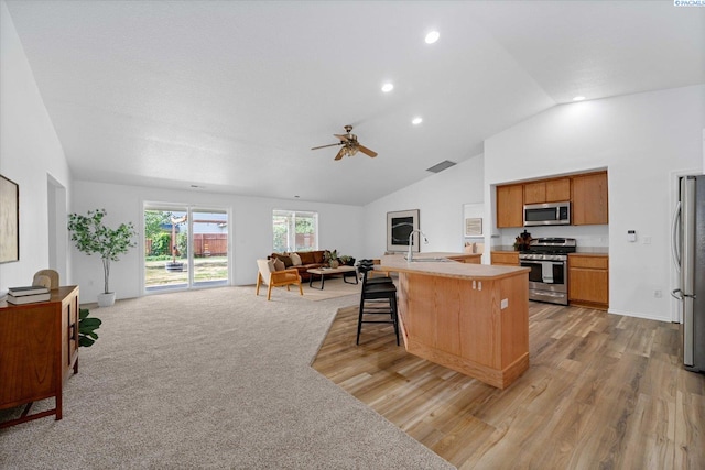 1713 W 39th Ave, Kennewick, WA 99337 - kitchen with appliances with stainless steel finishes, open floor plan, ceiling fan, light wood finished floors, and light countertops