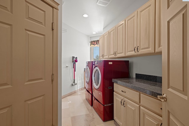 clothes washing area with cabinets and washing machine and clothes dryer