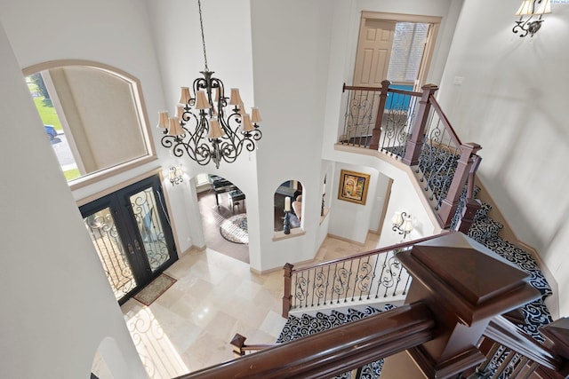 foyer entrance featuring french doors, a notable chandelier, and a high ceiling