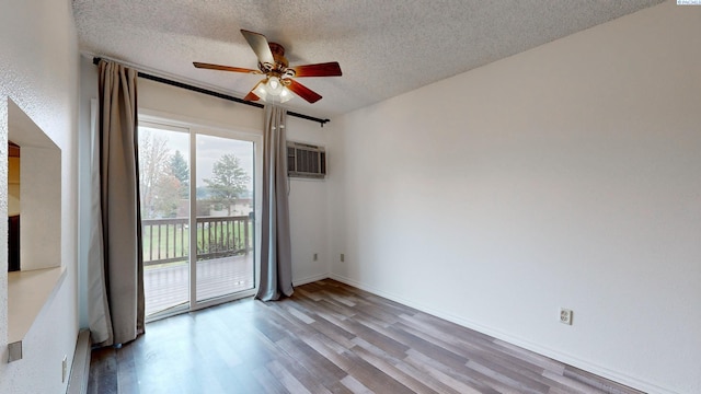 empty room with ceiling fan, wood-type flooring, a wall mounted AC, and a textured ceiling