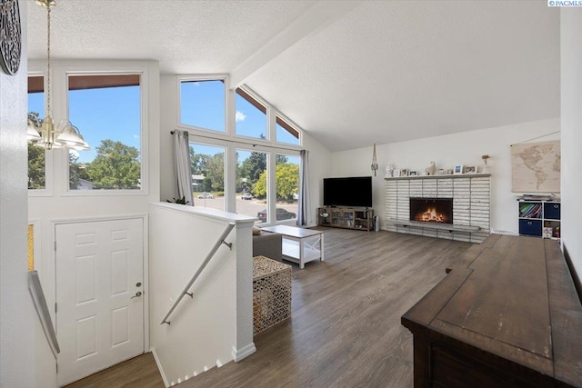 2132 Cascade Ave, Richland, WA 99354 - living room with healthy amount of natural light, wood finished floors, a textured ceiling, and a brick fireplace