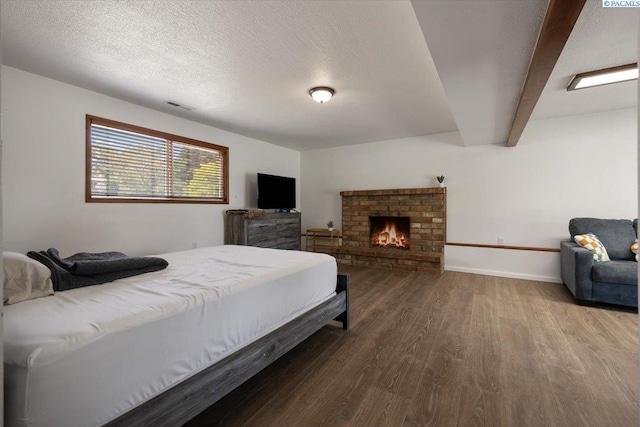 2132 Cascade Ave, Richland, WA 99354 - bedroom featuring wood finished floors, beam ceiling, a fireplace, and a textured ceiling