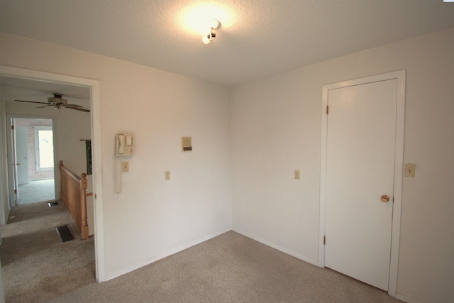unfurnished room with visible vents, a ceiling fan, baseboards, and light carpet