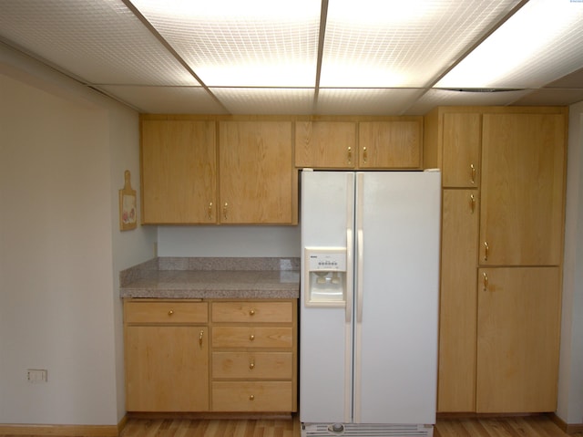 kitchen featuring light wood-type flooring, tile counters, light brown cabinetry, and white refrigerator with ice dispenser