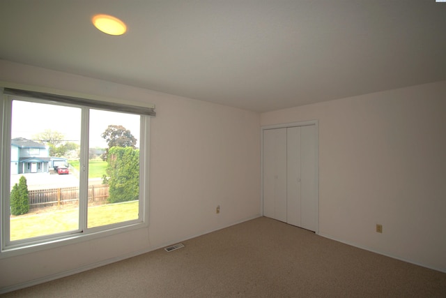 spare room with visible vents and light carpet
