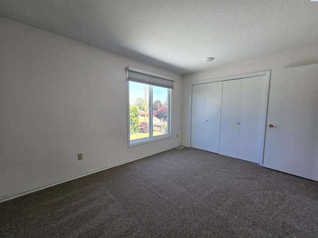 5307 W Irving St, Pasco, WA 99301 - unfurnished bedroom with dark colored carpet, a closet, and a textured ceiling