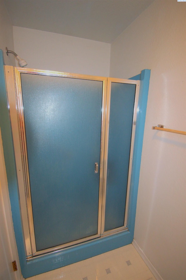 full bathroom featuring baseboards and a shower stall