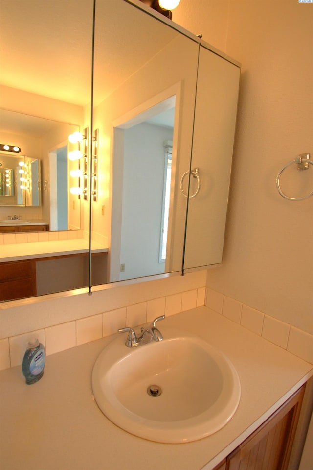 bathroom featuring vanity and tasteful backsplash