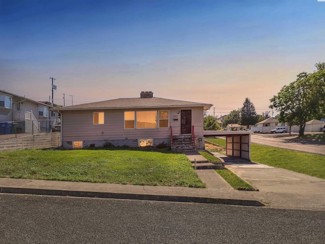 view of front of property with a carport and a yard