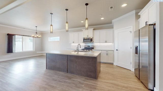 4801 White Dr, Richland, WA 99352 - kitchen with appliances with stainless steel finishes, an island with sink, sink, white cabinets, and hanging light fixtures