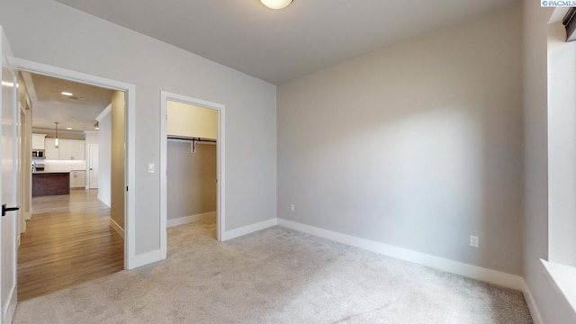 4801 White Dr, Richland, WA 99352 - unfurnished bedroom featuring light carpet, a spacious closet, and a closet