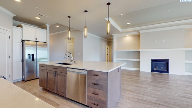 4801 White Dr, Richland, WA 99352 - kitchen featuring sink, appliances with stainless steel finishes, white cabinetry, a center island with sink, and light wood-type flooring