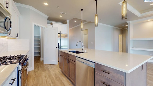 4801 White Dr, Richland, WA 99352 - kitchen with sink, appliances with stainless steel finishes, light hardwood / wood-style floors, white cabinets, and a center island with sink