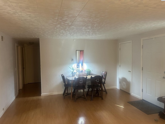 unfurnished dining area featuring baseboards and wood finished floors