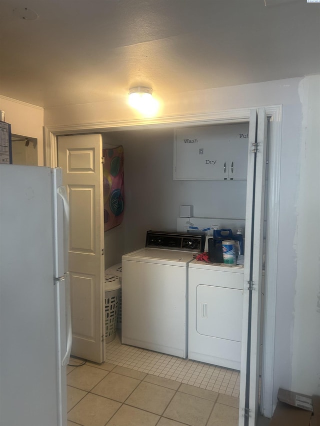 laundry area featuring laundry area, washing machine and clothes dryer, and light tile patterned floors