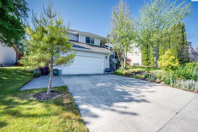 495 NW Robert St, Pullman, WA 99163 - view of front facade featuring concrete driveway, a front lawn, an attached garage, and stairway