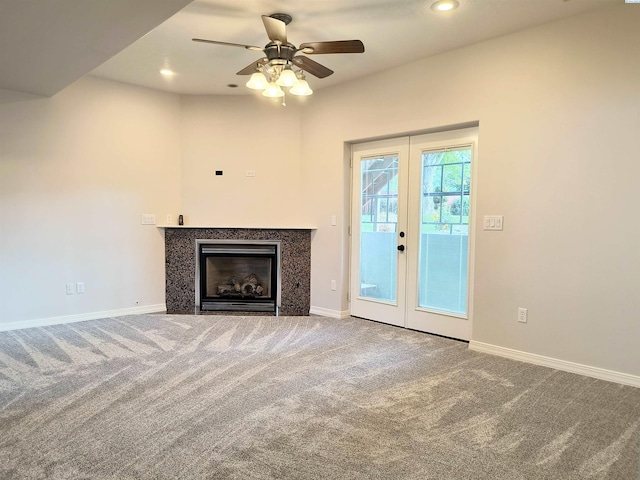 unfurnished living room with carpet, french doors, recessed lighting, a glass covered fireplace, and baseboards