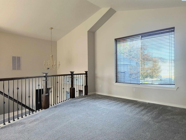 spare room with a chandelier, carpet, lofted ceiling, and visible vents