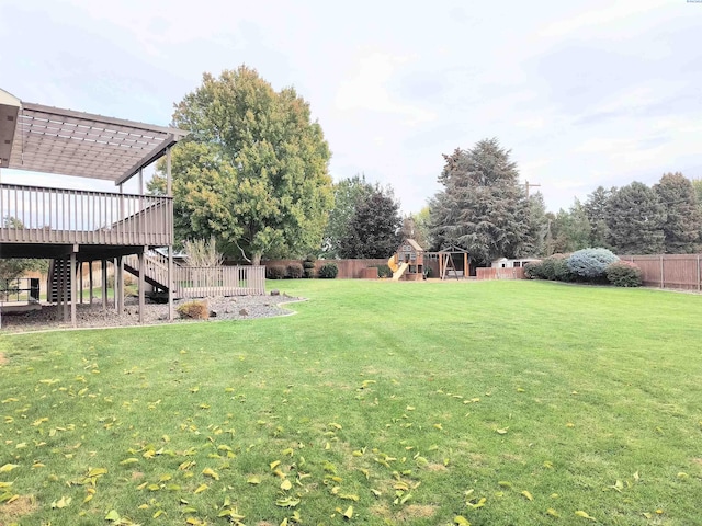 view of yard featuring a fenced backyard, stairway, a playground, and a wooden deck