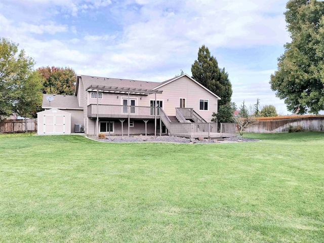 rear view of house featuring a deck, an outbuilding, fence, a yard, and a storage unit