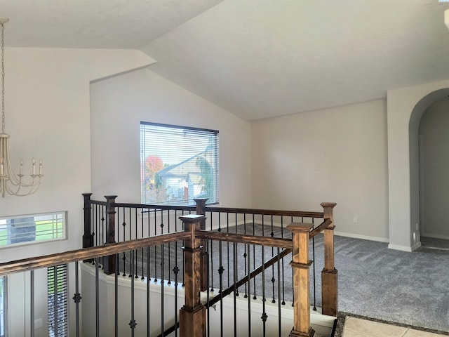 hallway with arched walkways, lofted ceiling, carpet floors, an upstairs landing, and baseboards