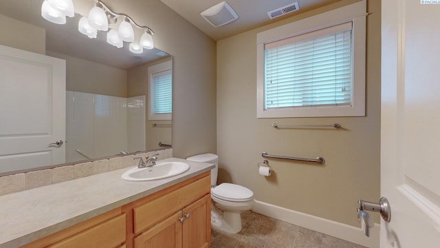 bathroom featuring tile patterned floors, vanity, toilet, and a shower