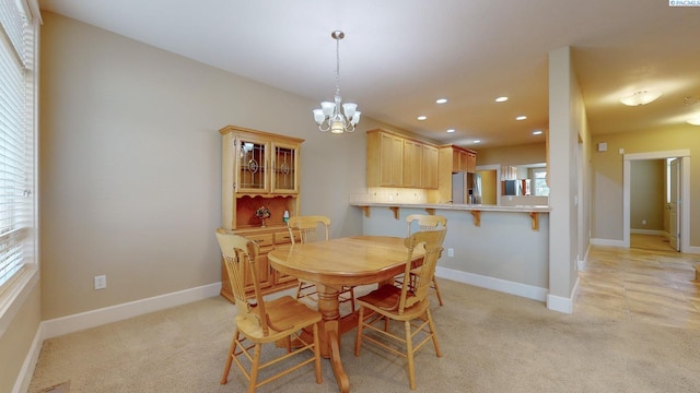 carpeted dining area featuring an inviting chandelier