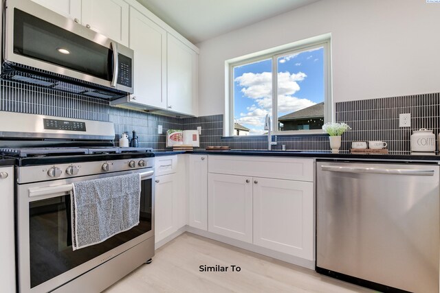 1608 Diamond Ave, Grandview, WA 98930 - kitchen with appliances with stainless steel finishes, a sink, white cabinets, dark countertops, and decorative backsplash