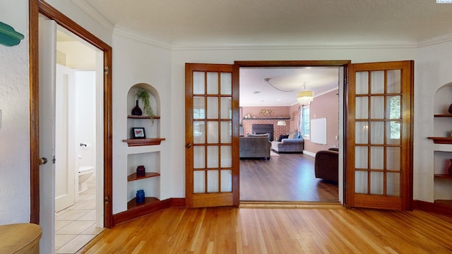 420 SE Dexter St, Pullman, WA 99163 - doorway featuring crown molding, built in features, a fireplace, wood finished floors, and french doors