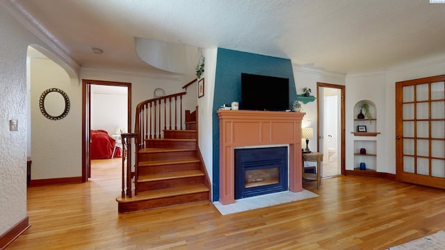 420 SE Dexter St, Pullman, WA 99163 - living room featuring crown molding, light wood finished floors, stairway, and a fireplace with flush hearth