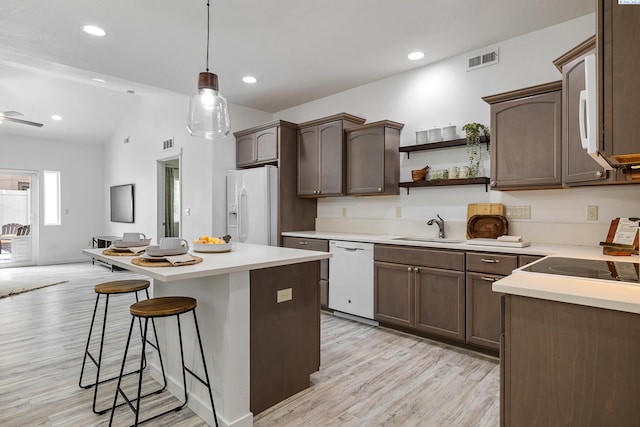 kitchen featuring dark brown cabinets, sink, white appliances, and pendant lighting