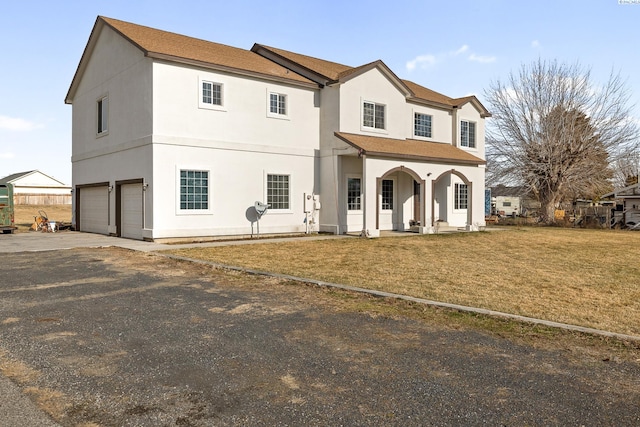 view of front of house with a garage, covered porch, and a front lawn