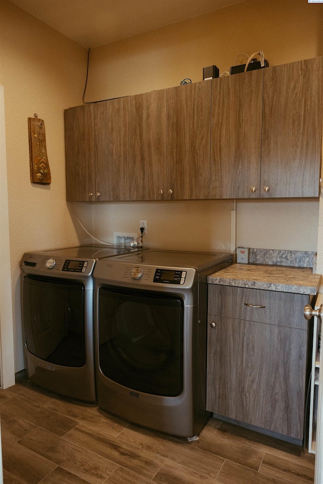 clothes washing area with independent washer and dryer and cabinets