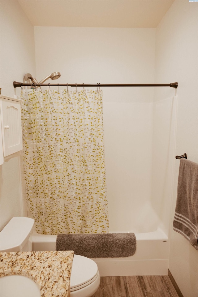 bathroom with shower / tub combo, hardwood / wood-style floors, and toilet