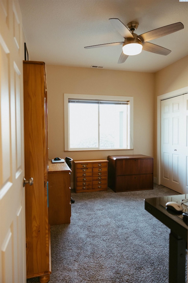 interior space featuring ceiling fan and carpet