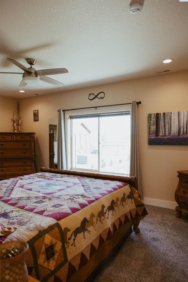 bedroom featuring ceiling fan, carpet floors, and a textured ceiling