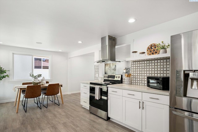 2115 W 8th Pl, Kennewick, WA 99336 - kitchen featuring island range hood, appliances with stainless steel finishes, light wood-style floors, white cabinetry, and baseboards
